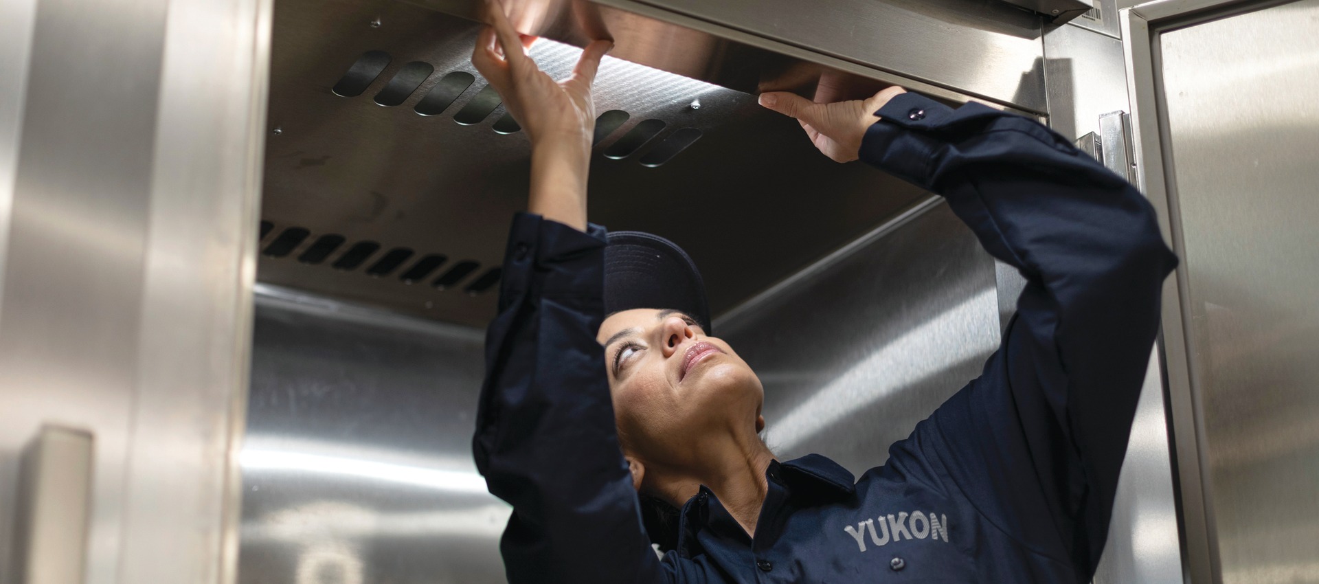 Yukon Refrigeration technician inspecting a commercial kitchen exhaust hood