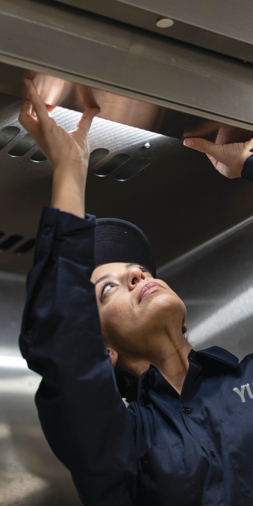 Yukon Refrigeration technician inspecting a commercial kitchen exhaust hood