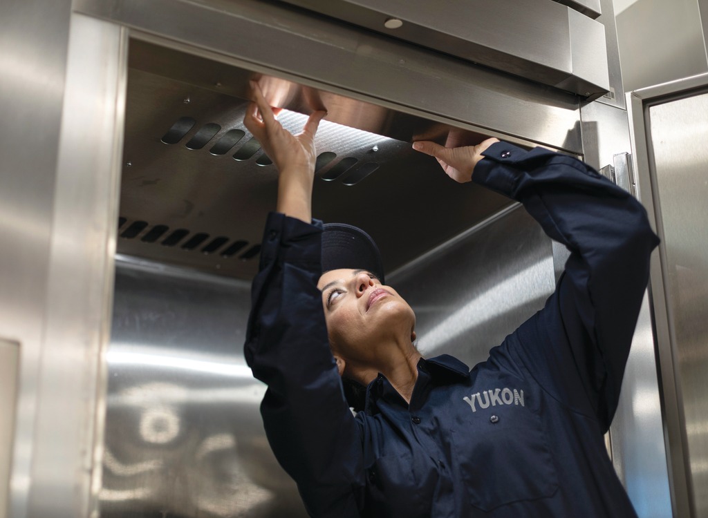 Yukon Refrigeration technician inspecting a commercial kitchen exhaust hood